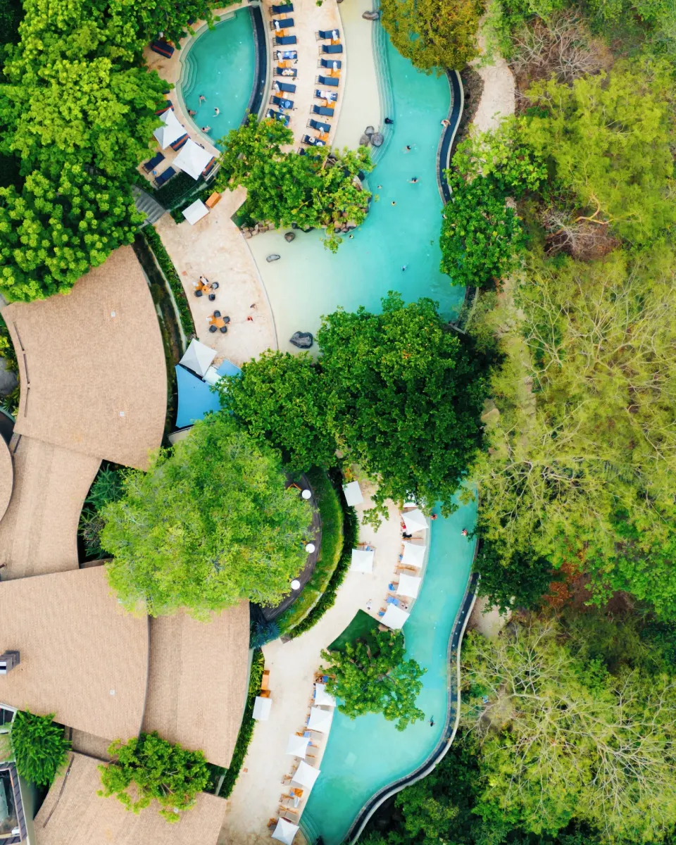 Aerial view of winding pools and trees at Andaz Peninsula Papagayo Resort, Costa Rica.
