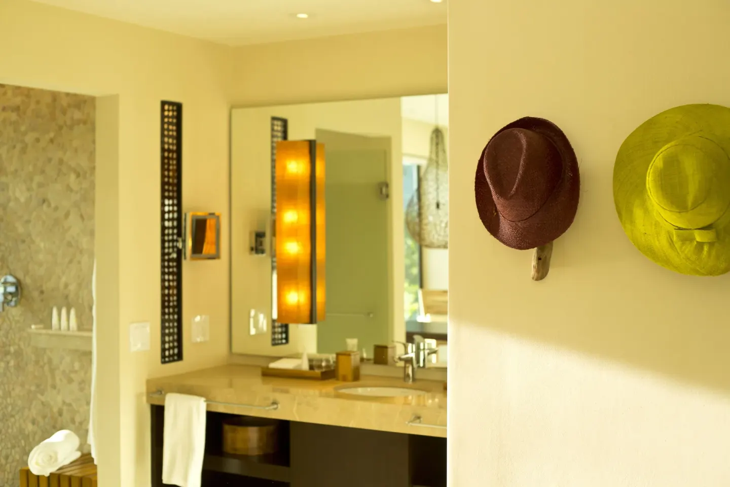 Bathroom vanity and wall hooks with hats at Andaz Peninsula Papagayo Resort, Costa Rica.