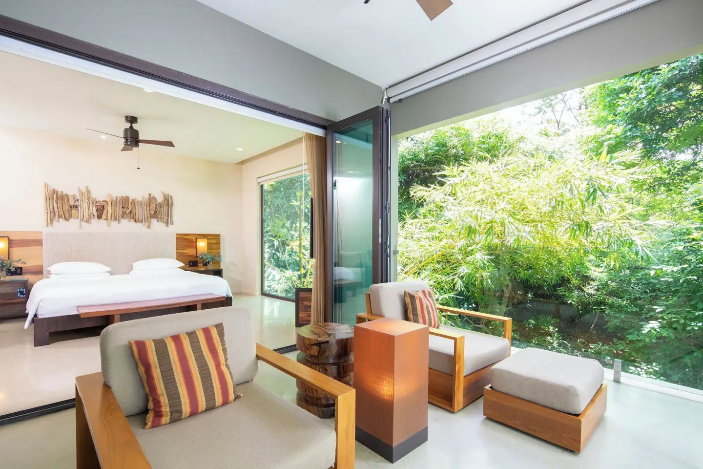 Guest room terrace seating faces lush greenery at Andaz Peninsula Papagayo Resort, Costa Rica.