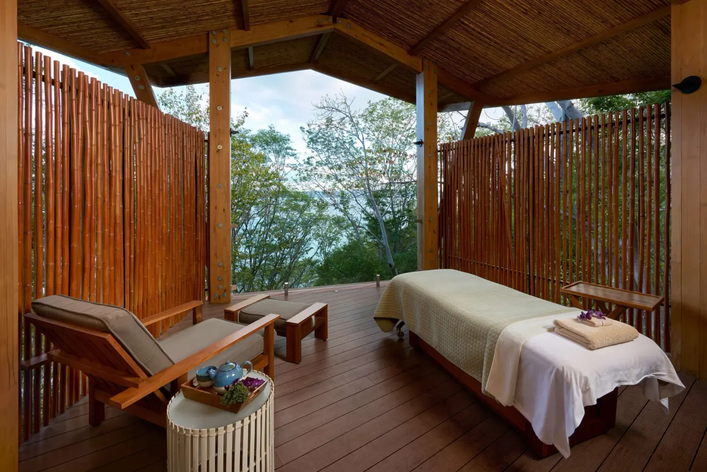Open-air spa deck with massage table and lounge chair at Andaz Peninsula Papagayo Resort, Costa Rica.