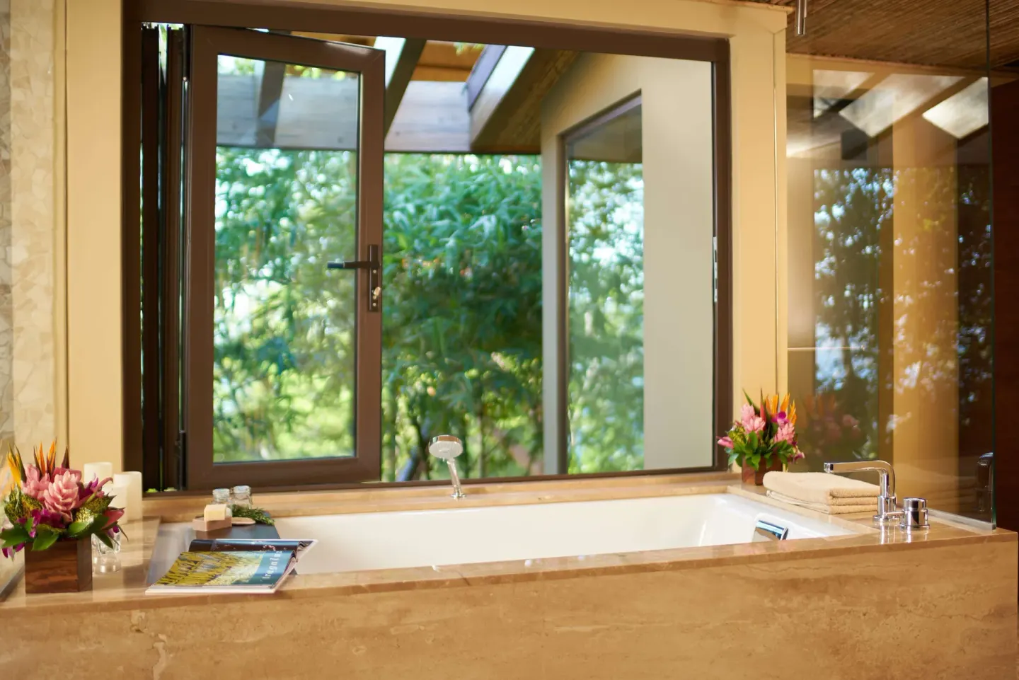 Soaking tub beside open windows and tropical greenery at Andaz Peninsula Papagayo Resort, Costa Rica.
