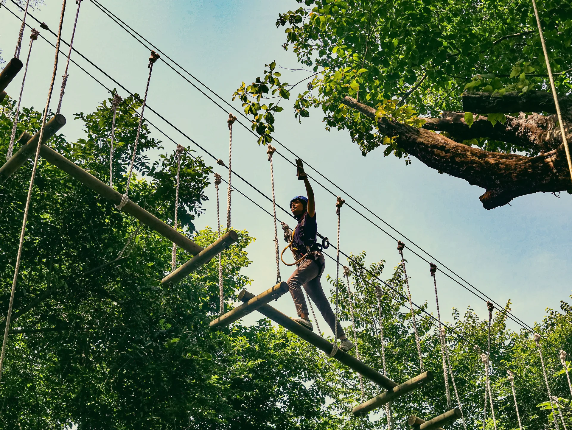 Guest crosses a treetop ropes course at Andaz Peninsula Papagayo Resort, Costa Rica.