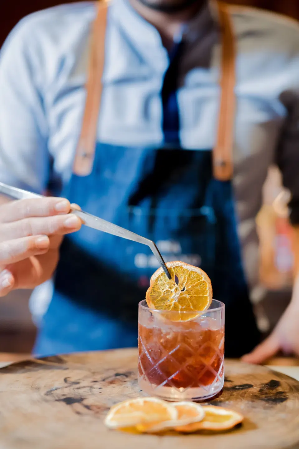 Bartender places a dried citrus garnish on a cocktail at Andaz Peninsula Papagayo Resort, Costa Rica.