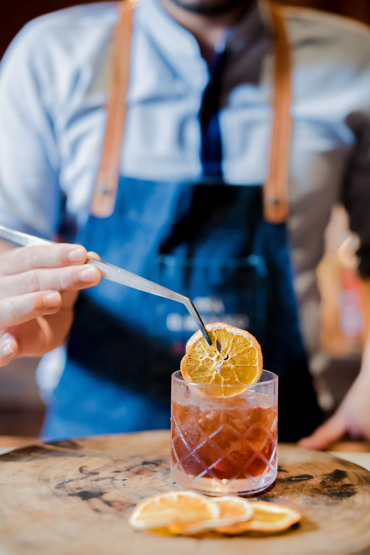 Bartender places a dried citrus garnish on a cocktail at Andaz Peninsula Papagayo Resort, Costa Rica.