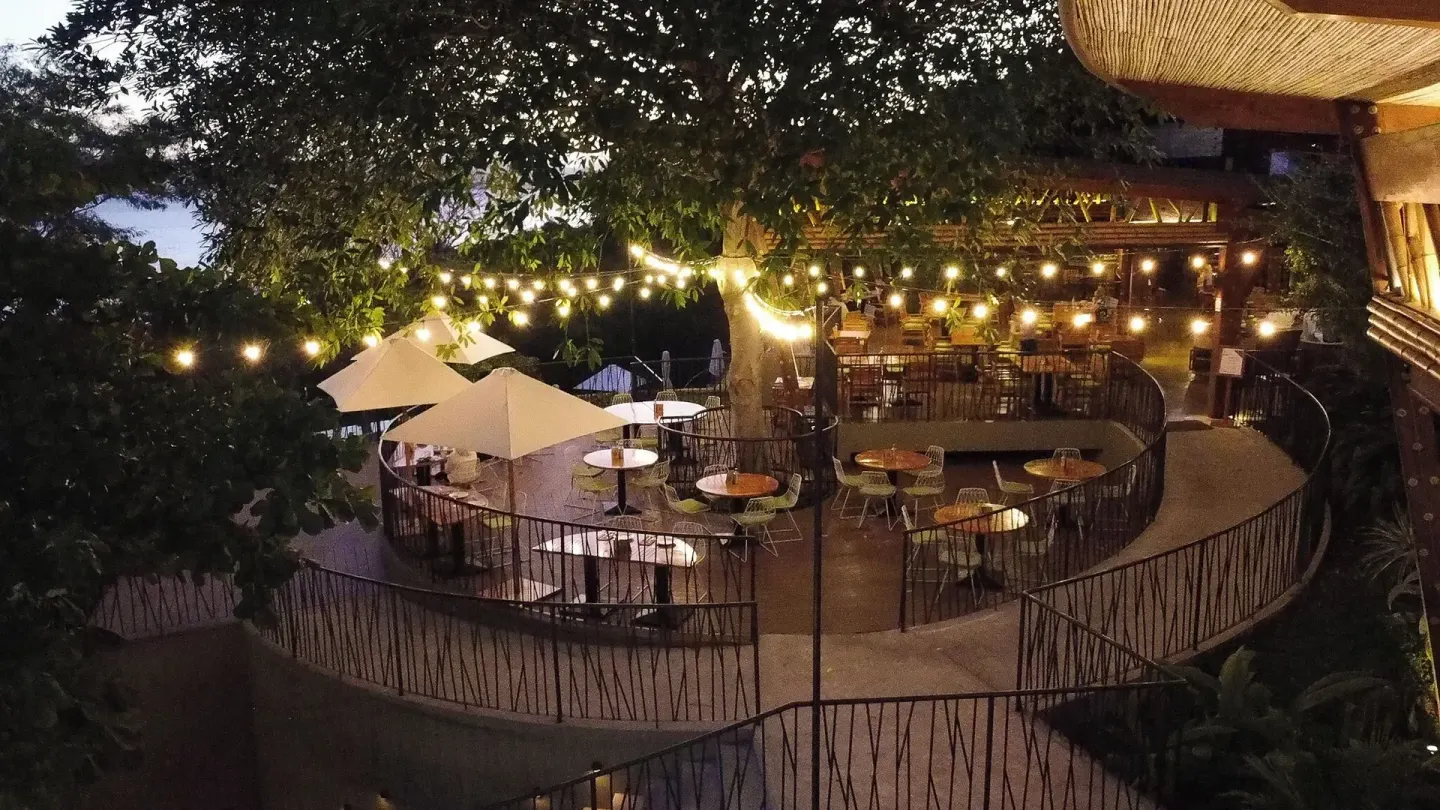 Outdoor dining terrace lit by string lights at Andaz Peninsula Papagayo Resort, Costa Rica.
