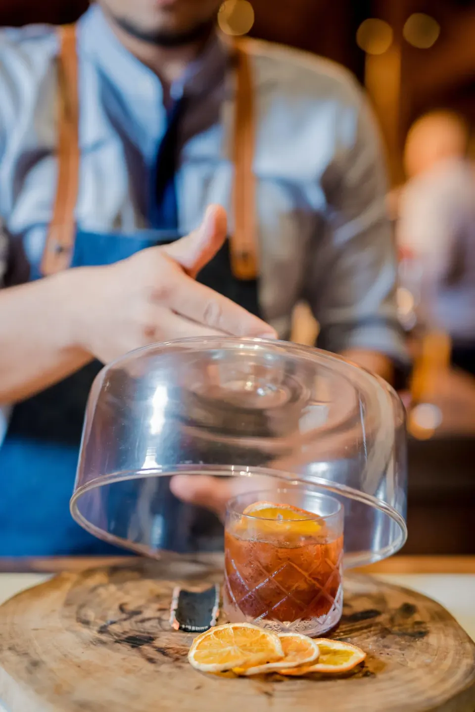 Bartender reveals a smoked cocktail under a glass cloche at Andaz Peninsula Papagayo Resort, Costa Rica.