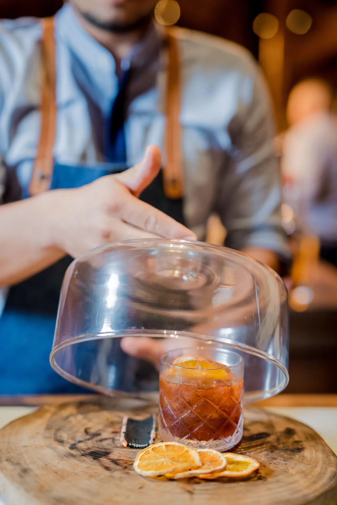 Bartender reveals a smoked cocktail under a glass cloche at Andaz Peninsula Papagayo Resort, Costa Rica.