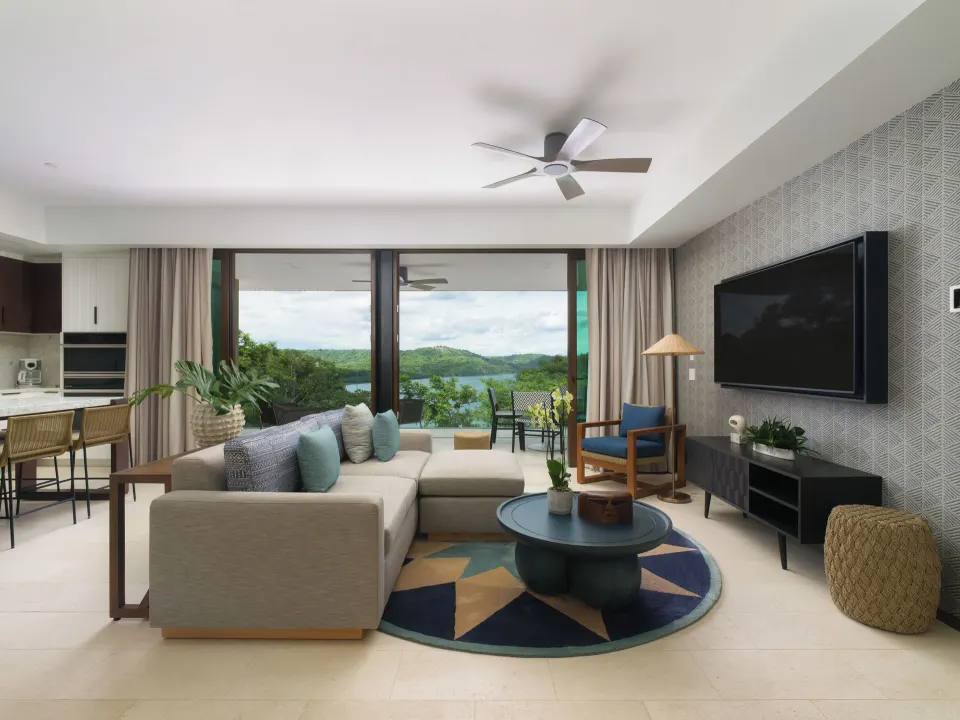 Penthouse living room with sofa, TV and bay view at Andaz Peninsula Papagayo Resort, Costa Rica.