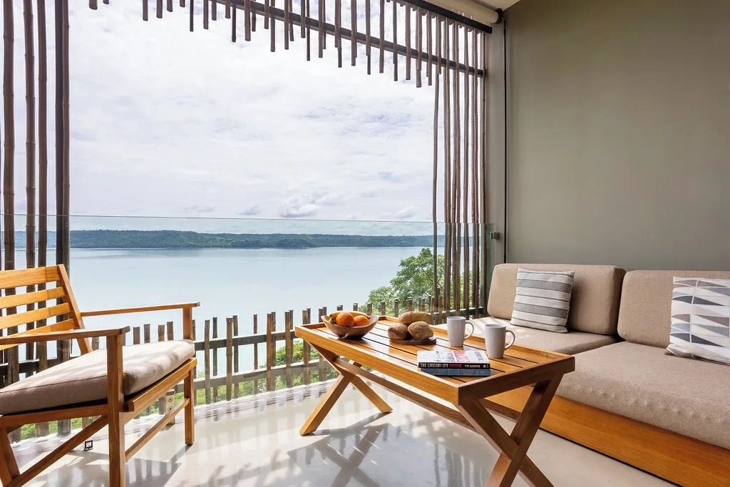 Bay View room balcony with sofa, chair and coffee table at Andaz Peninsula Papagayo Resort, Costa Rica.