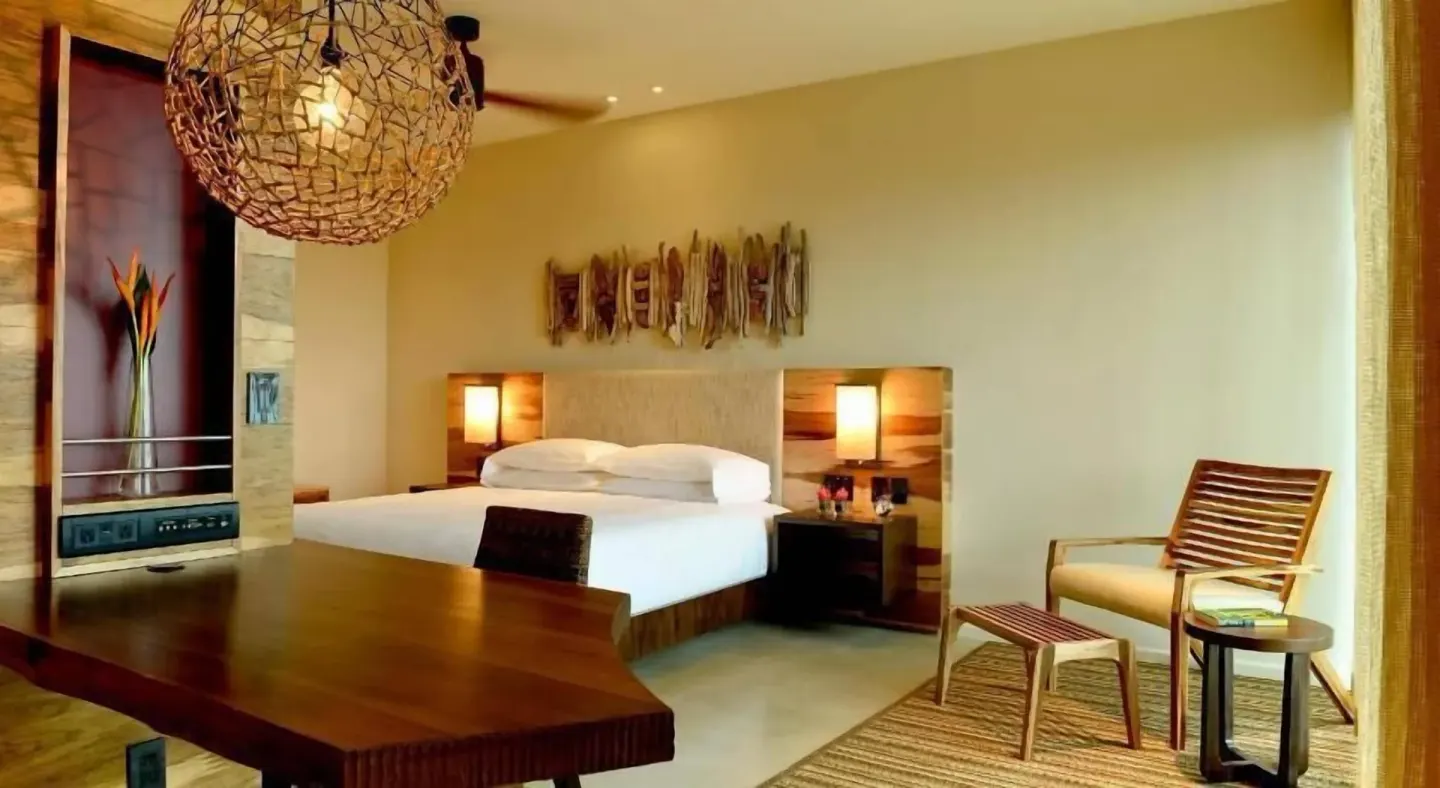 Room Forest View bed, dining table, and lounge chair at Andaz Peninsula Papagayo Resort, Costa Rica.
