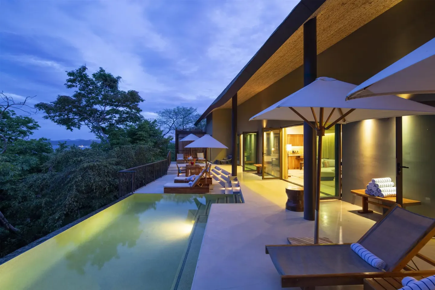 Two-bedroom Papagayo pool suite terrace at Andaz Peninsula Papagayo Resort, Costa Rica with loungers and umbrellas.