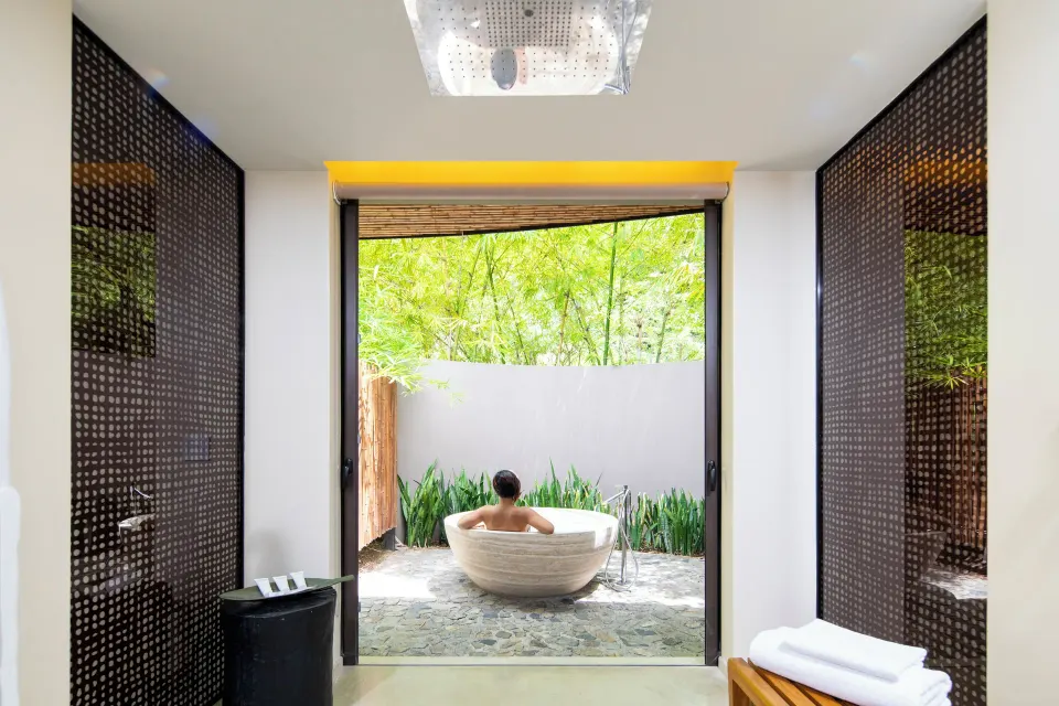Bathroom with indoor shower and outdoor soaking tub at Andaz Peninsula Papagayo Resort, Costa Rica.