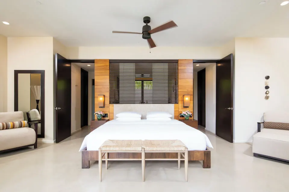 King bedroom with bench and open doorways at Andaz Peninsula Papagayo Resort, Costa Rica.