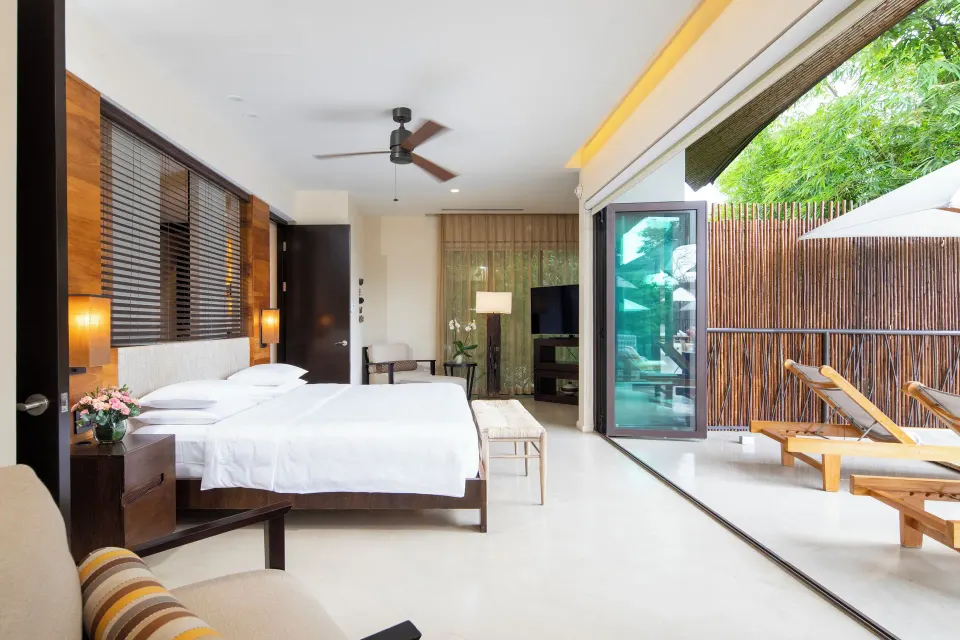 Pool suite bedroom with king bed and terrace loungers at Andaz Peninsula Papagayo Resort, Costa Rica.