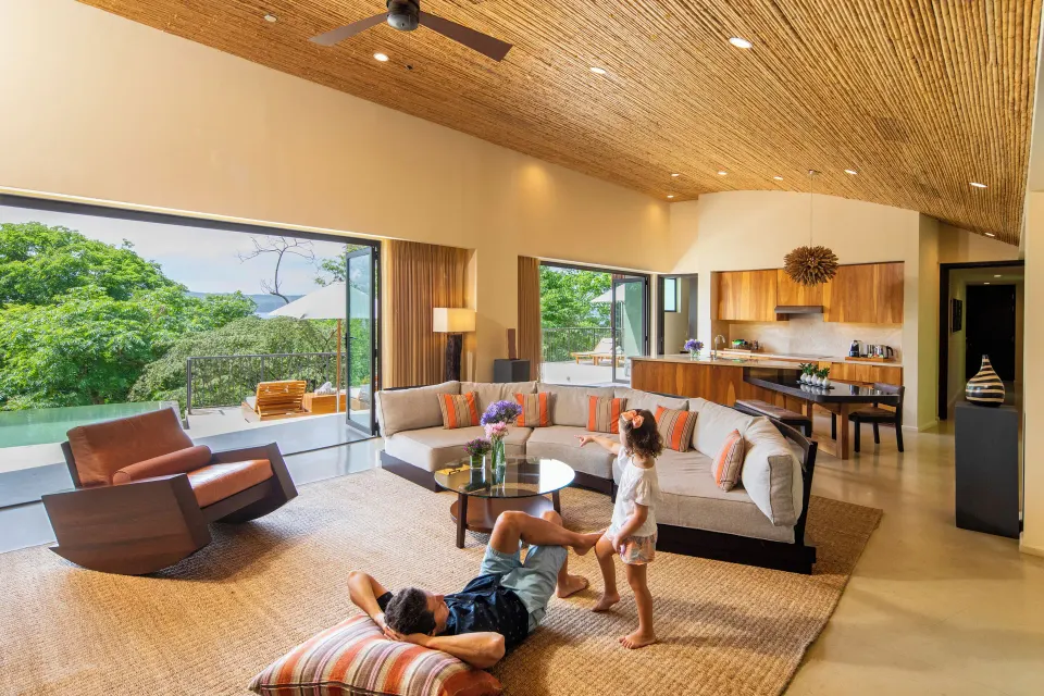 Pool suite living room with sofa and open kitchen at Andaz Peninsula Papagayo Resort, Costa Rica.