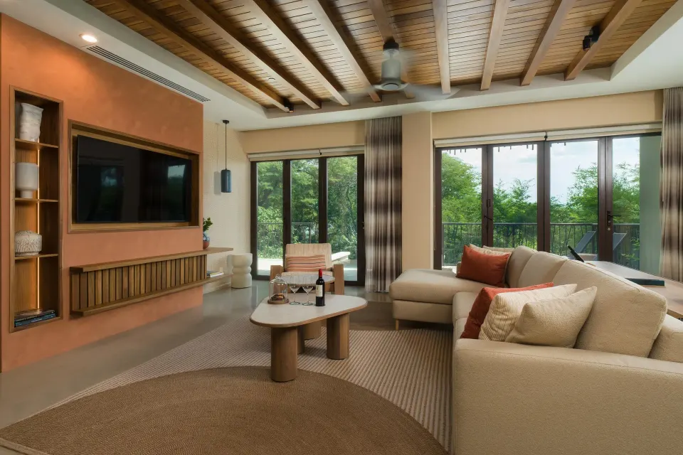 Suite living room with sectional sofa and balcony doors at Andaz Peninsula Papagayo Resort, Costa Rica.