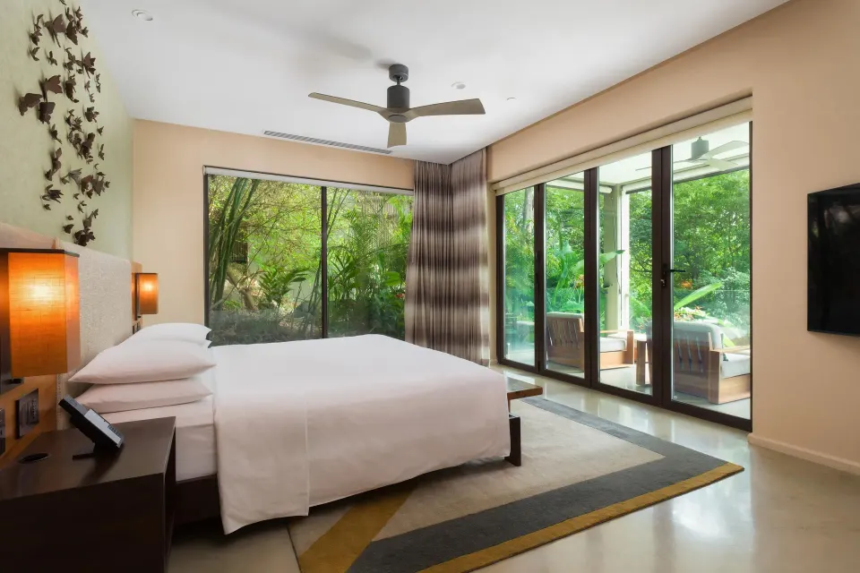 King bedroom with glass doors to the terrace at Andaz Peninsula Papagayo Resort, Costa Rica.