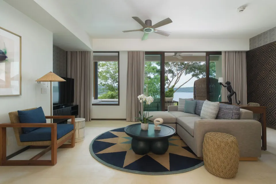 Villa living room with sofa and water-view windows at Andaz Peninsula Papagayo Resort, Costa Rica.