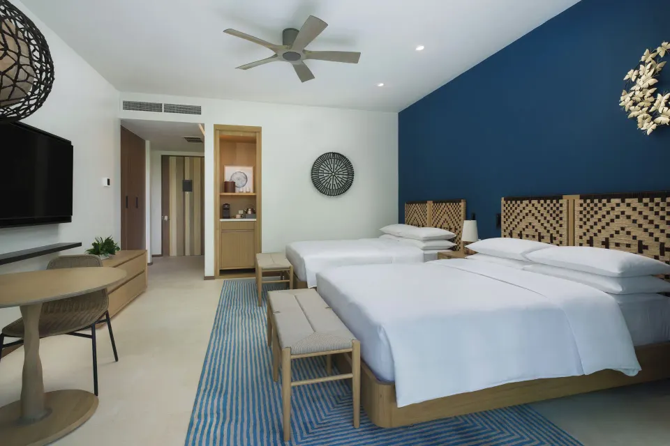 Two-bed villa bedroom with blue accent wall at Andaz Peninsula Papagayo Resort, Costa Rica.
