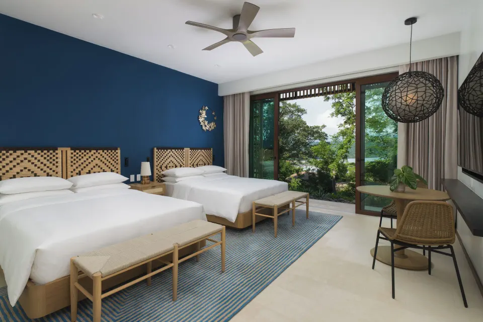 Two-bed villa bedroom with garden-facing windows at Andaz Peninsula Papagayo Resort, Costa Rica.