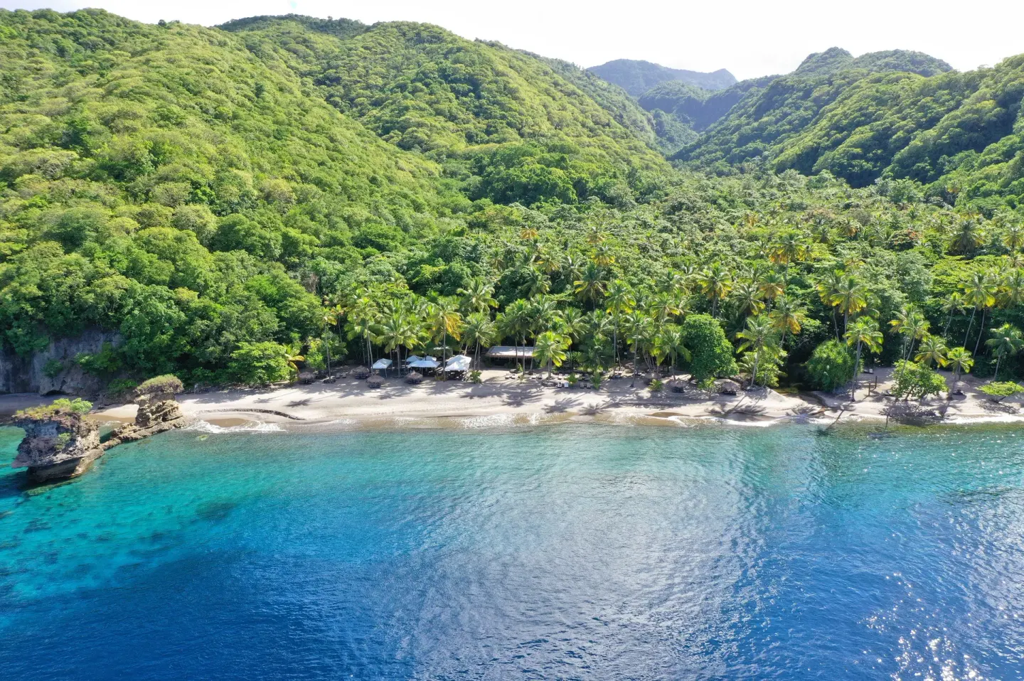 Aerial beach and turquoise water at Anse Chastanet Resort backed by green hills and palms.