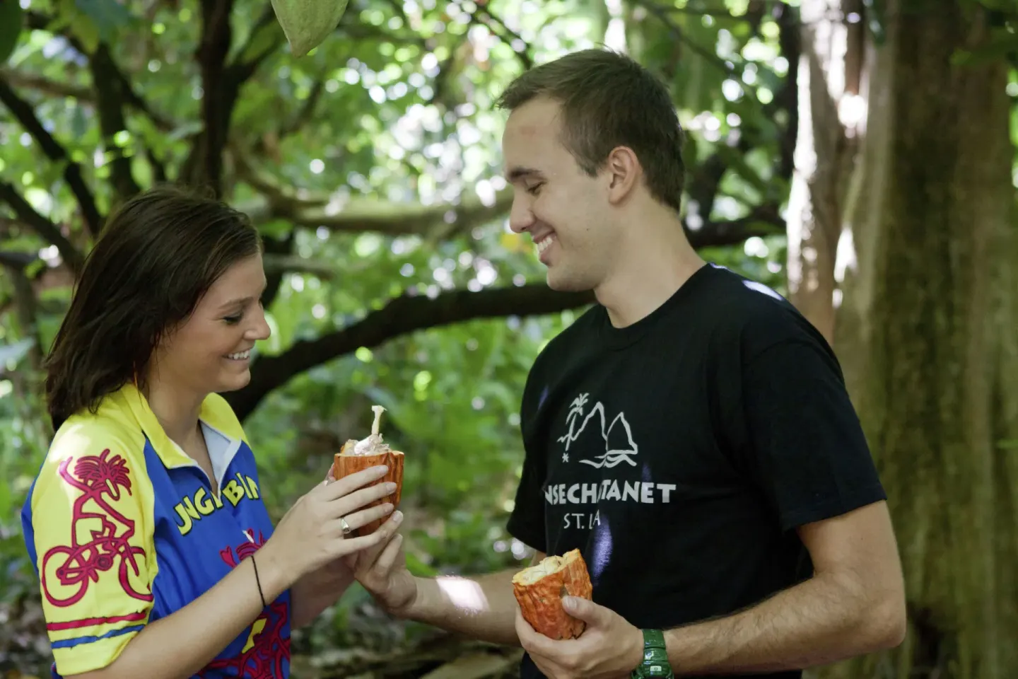 Guests hold opened cacao pods in a forest setting at Anse Chastanet Resort.