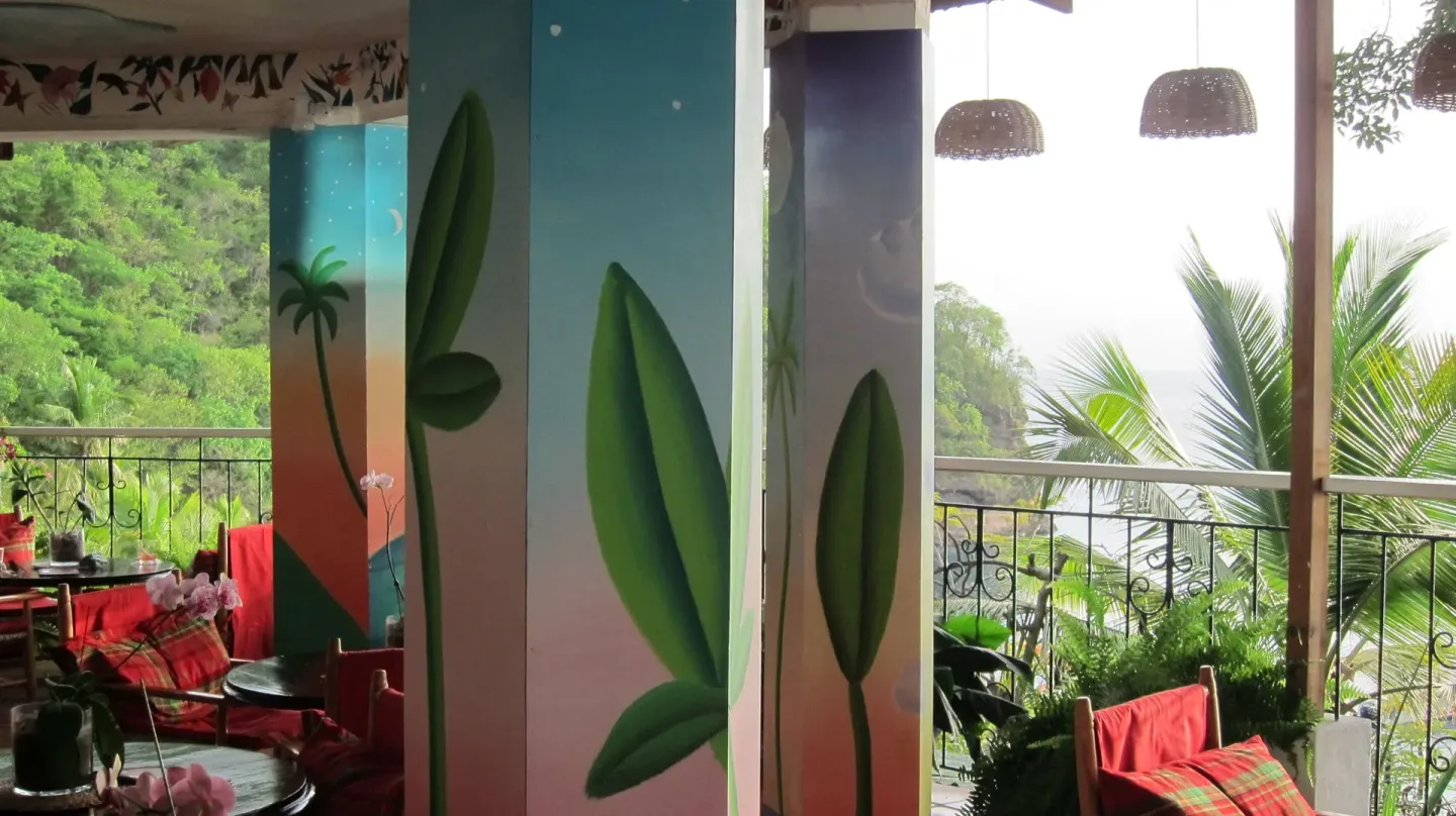 Colorful open-air lounge at Anse Chastanet Resort with painted columns and balcony sea views.