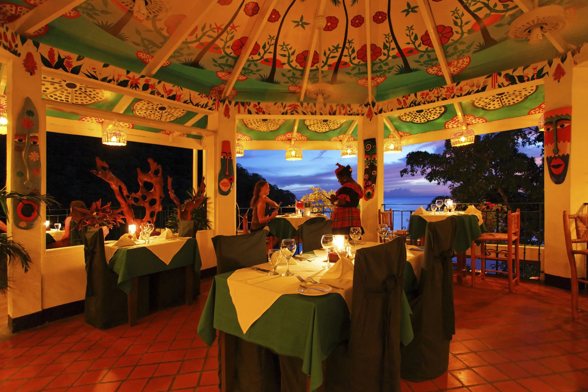 Colorful open-air dining room with candlelit tables at Anse Chastanet Resort.