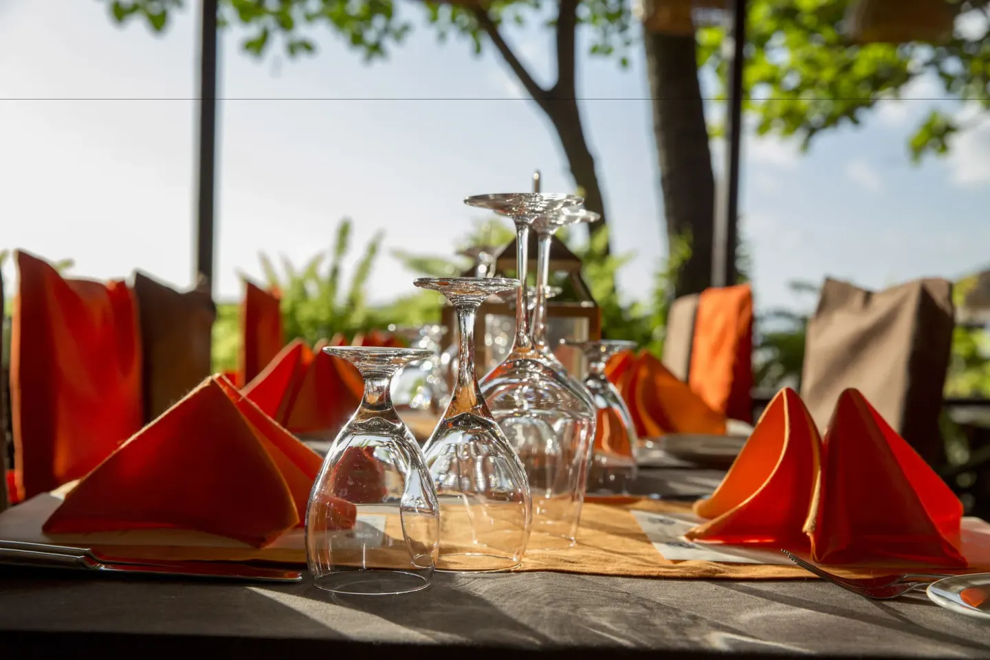 Table setting with orange napkins and wine glasses at Anse Chastanet Resort.