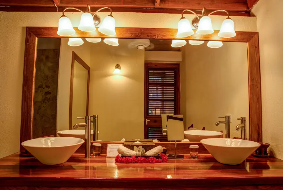 Deluxe Beachside Room bathroom with twin vessel sinks and wood vanity at Anse Chastanet Resort.