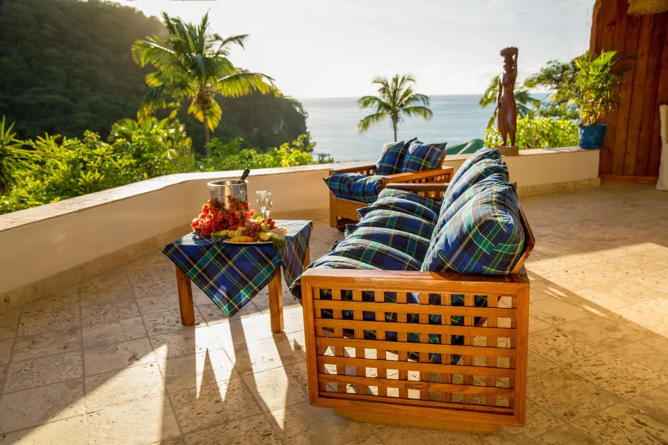 Hillside Deluxe Oceanview terrace with blue-cushioned sofas at Anse Chastanet Resort.