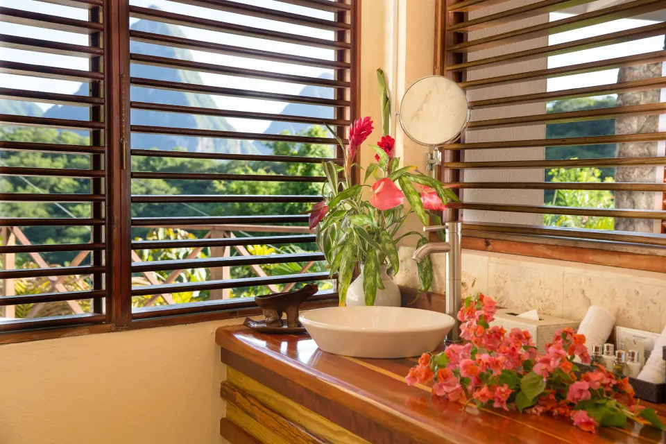 Hillside Deluxe Oceanview vanity with flowers and louvered windows at Anse Chastanet Resort.