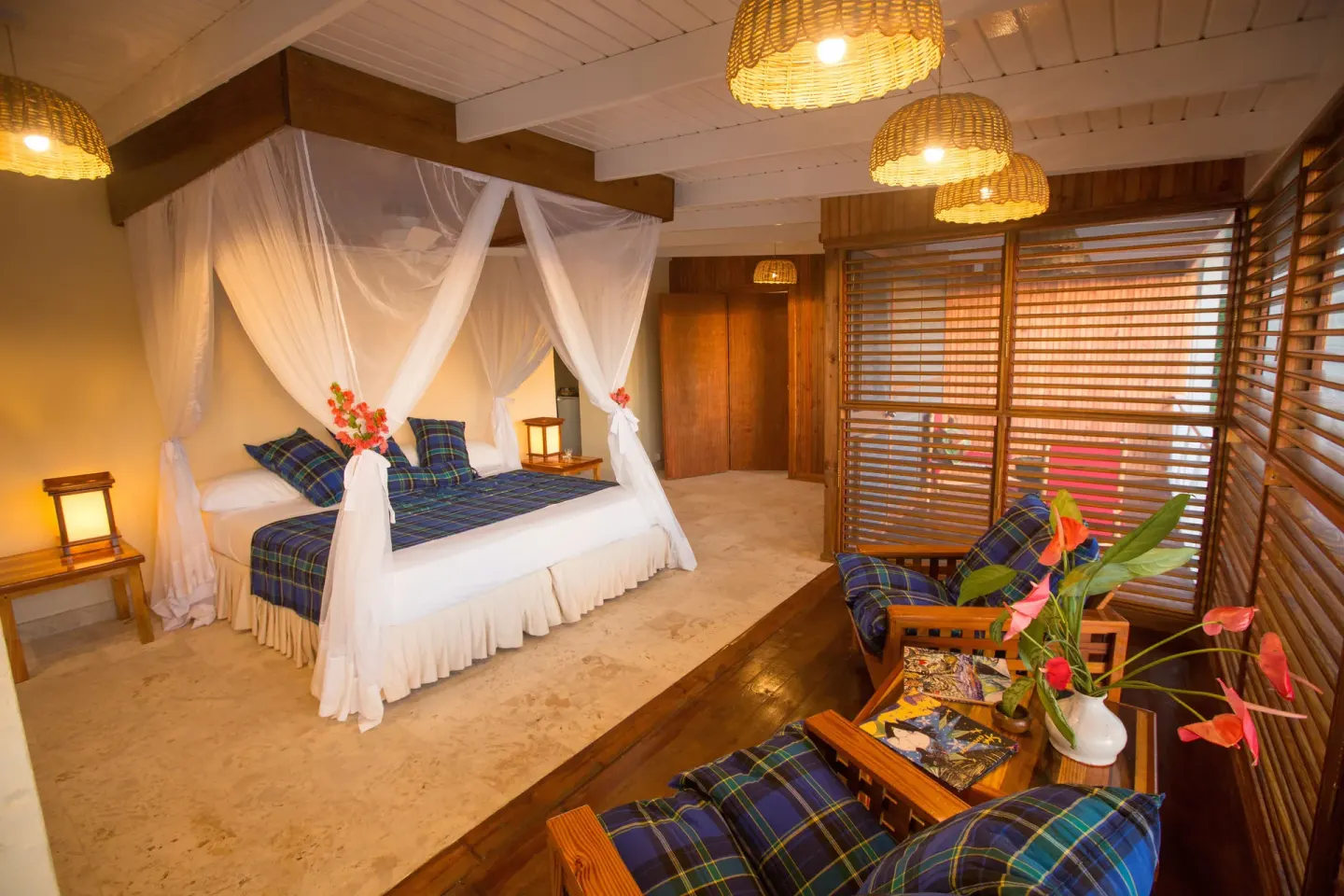 Standard Room with canopy bed, lounge chairs and woven ceiling lights at Anse Chastanet Resort.