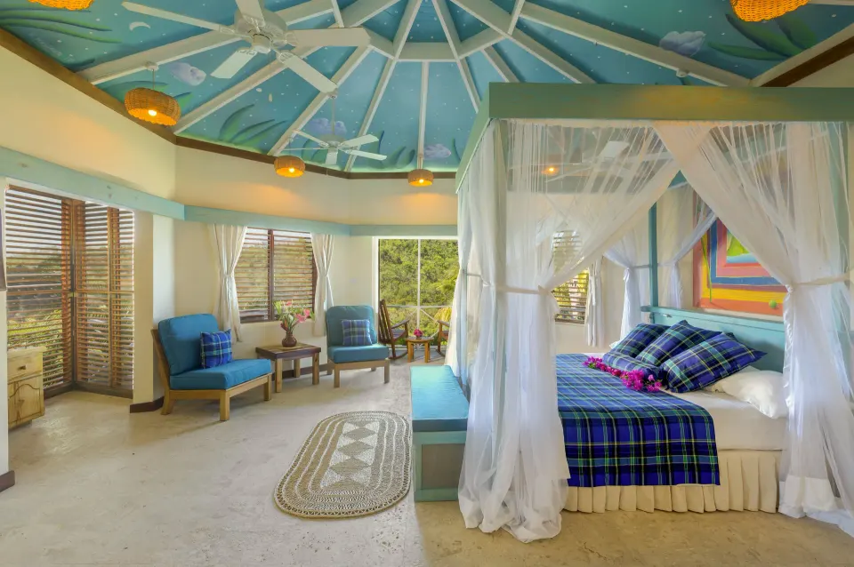 Superior Room Ocean View with canopy bed and sitting area at Anse Chastanet Resort.