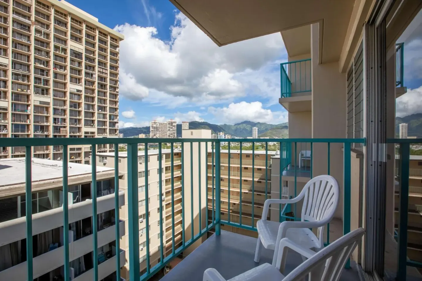 Balcony with white chairs and city-mountain views at Aqua Aloha Surf Waikiki.