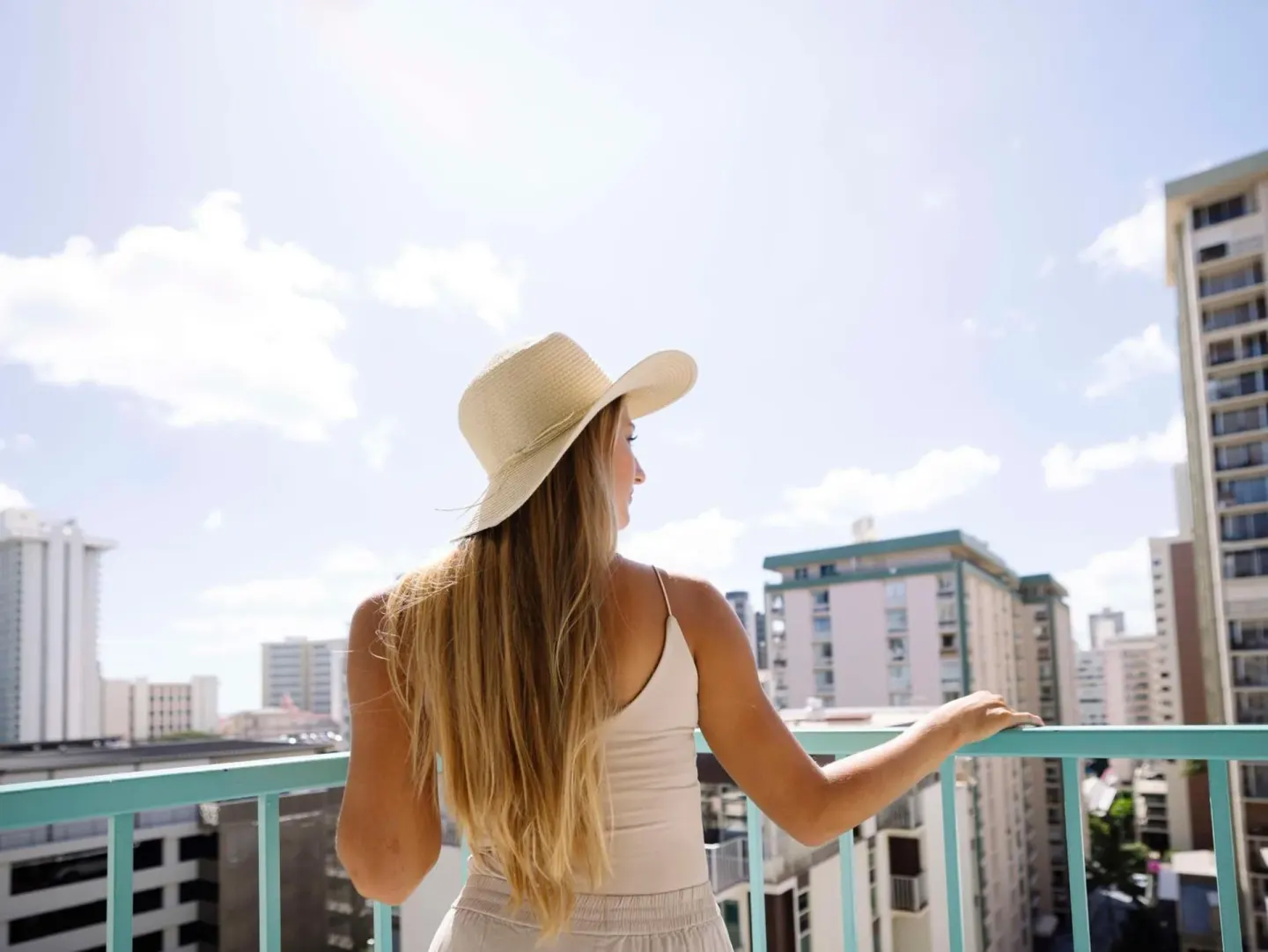 Guest on a balcony looking over Waikiki buildings at Aqua Aloha Surf Waikiki.