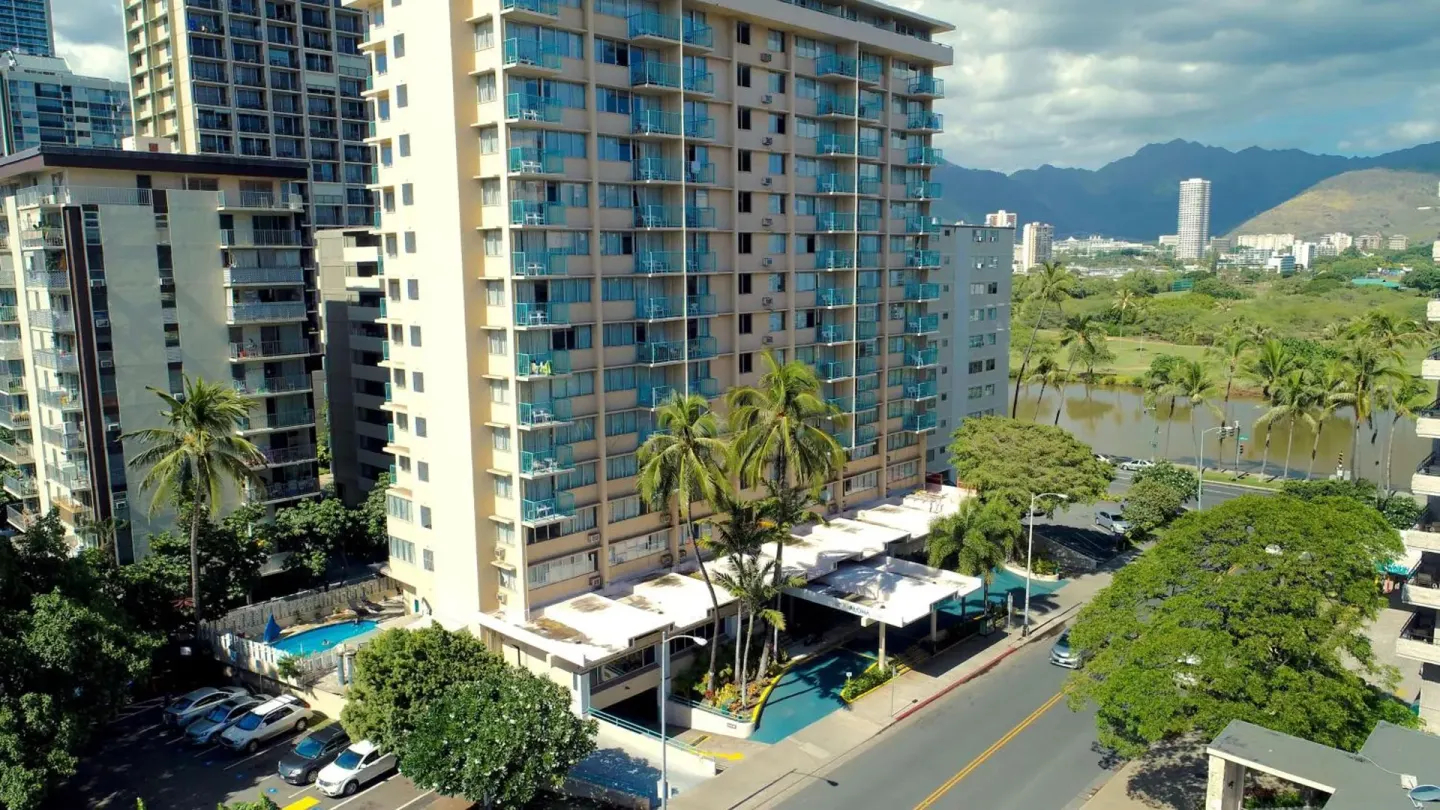 Elevated street view of Aqua Aloha Surf Waikiki with pool and palms.