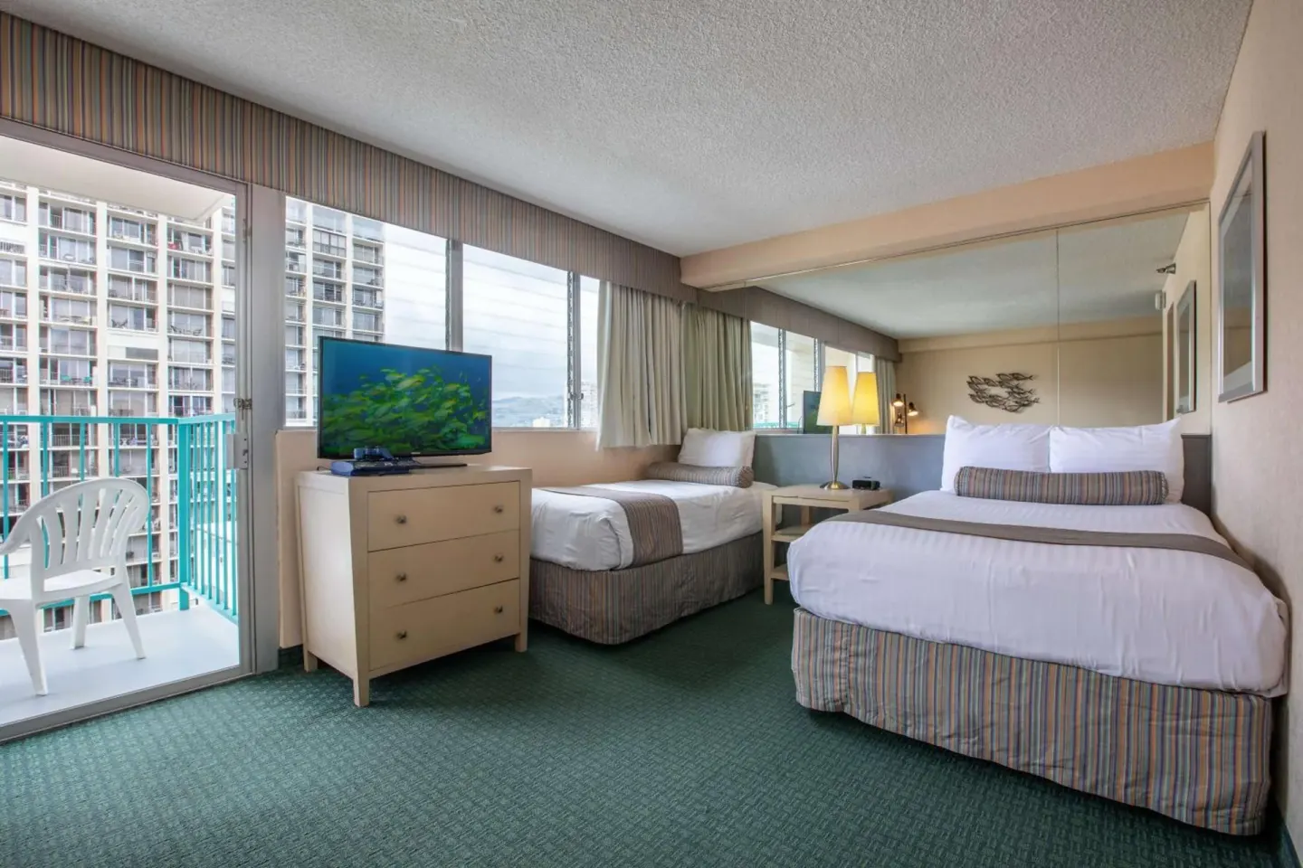 Two-bed guest room with balcony and dresser at Aqua Aloha Surf Waikiki.