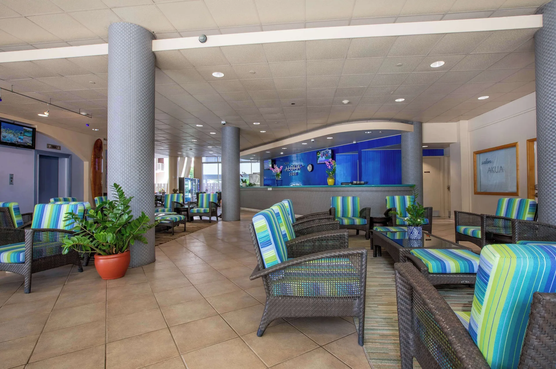 Lobby seating with striped cushions and front desk at Aqua Aloha Surf Waikiki.