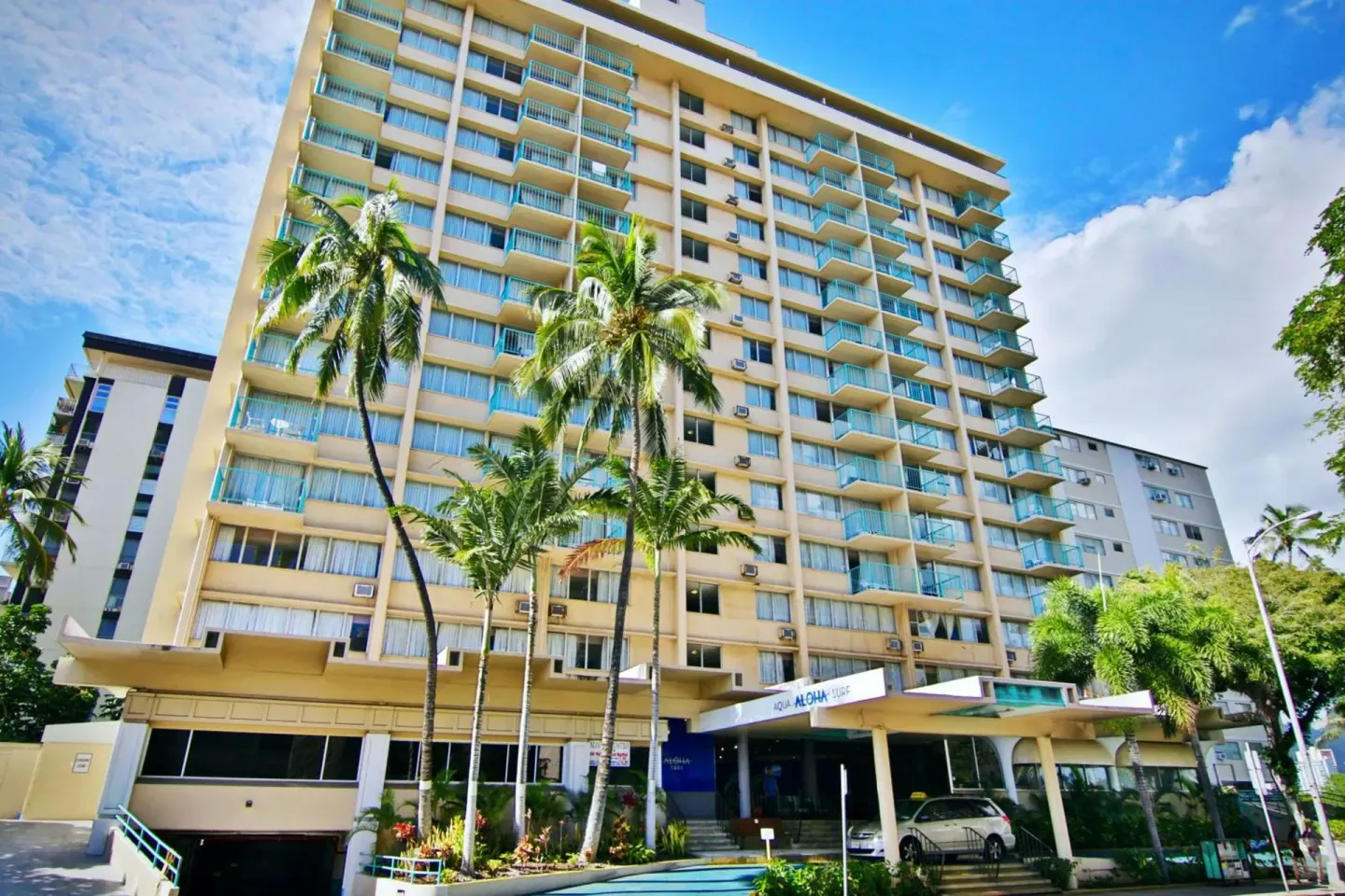 Palm trees and turquoise balconies on the exterior of Aqua Aloha Surf Waikiki.