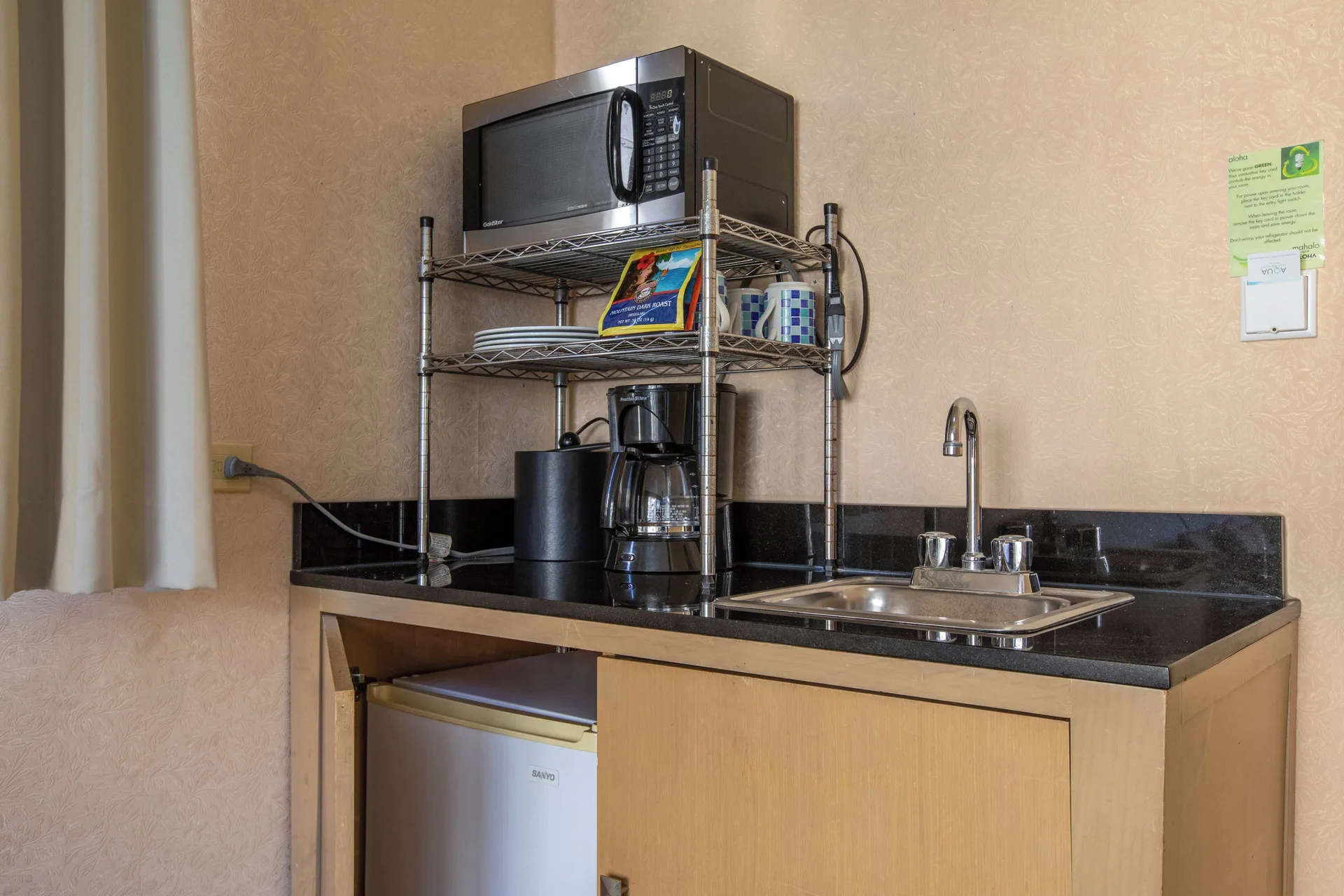 Junior Suite kitchenette with microwave, sink, coffee maker, and mini fridge at Aqua Aloha Surf Waikiki.