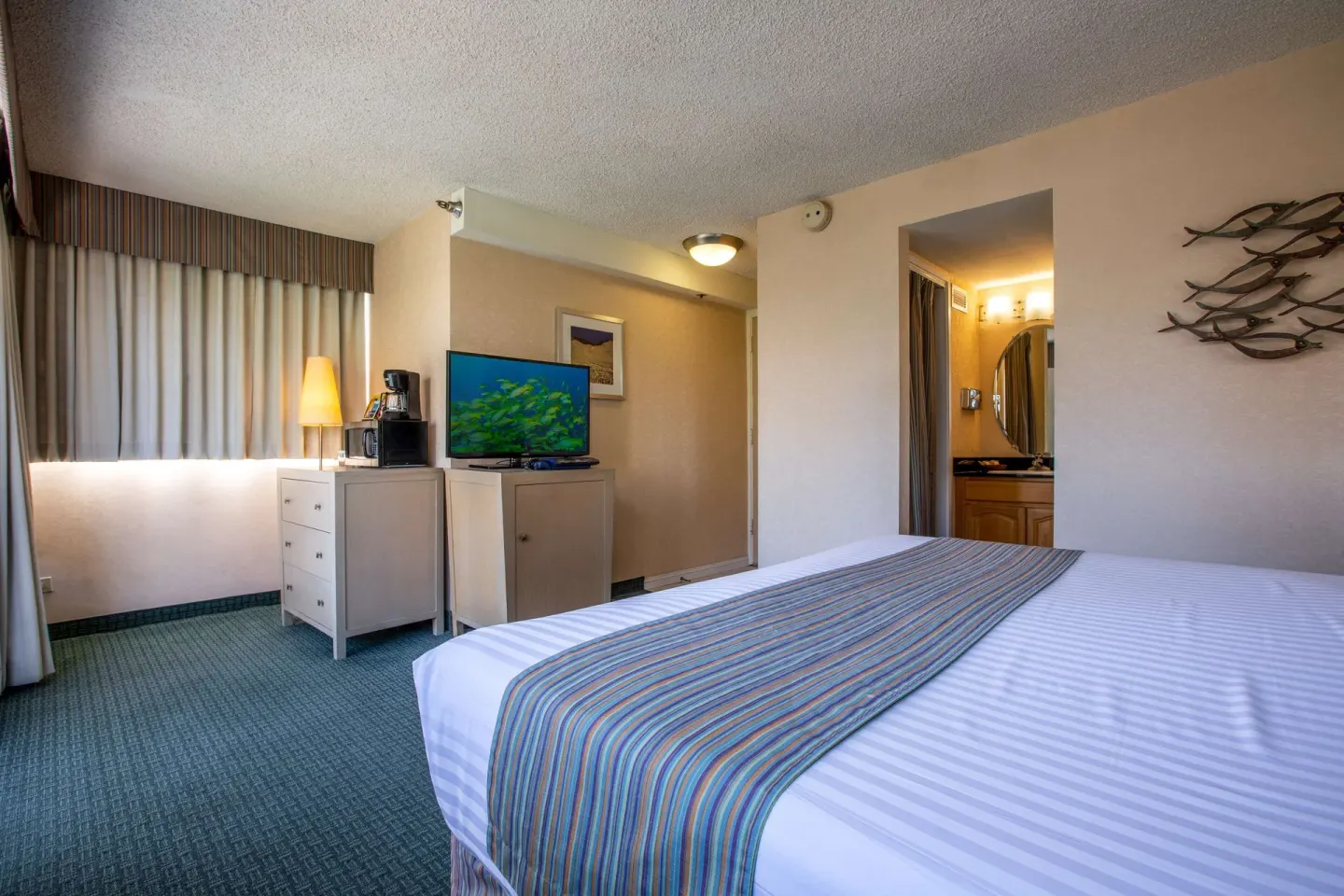 Superior Room with king bed, TV, dresser, and bath entry at Aqua Aloha Surf Waikiki.