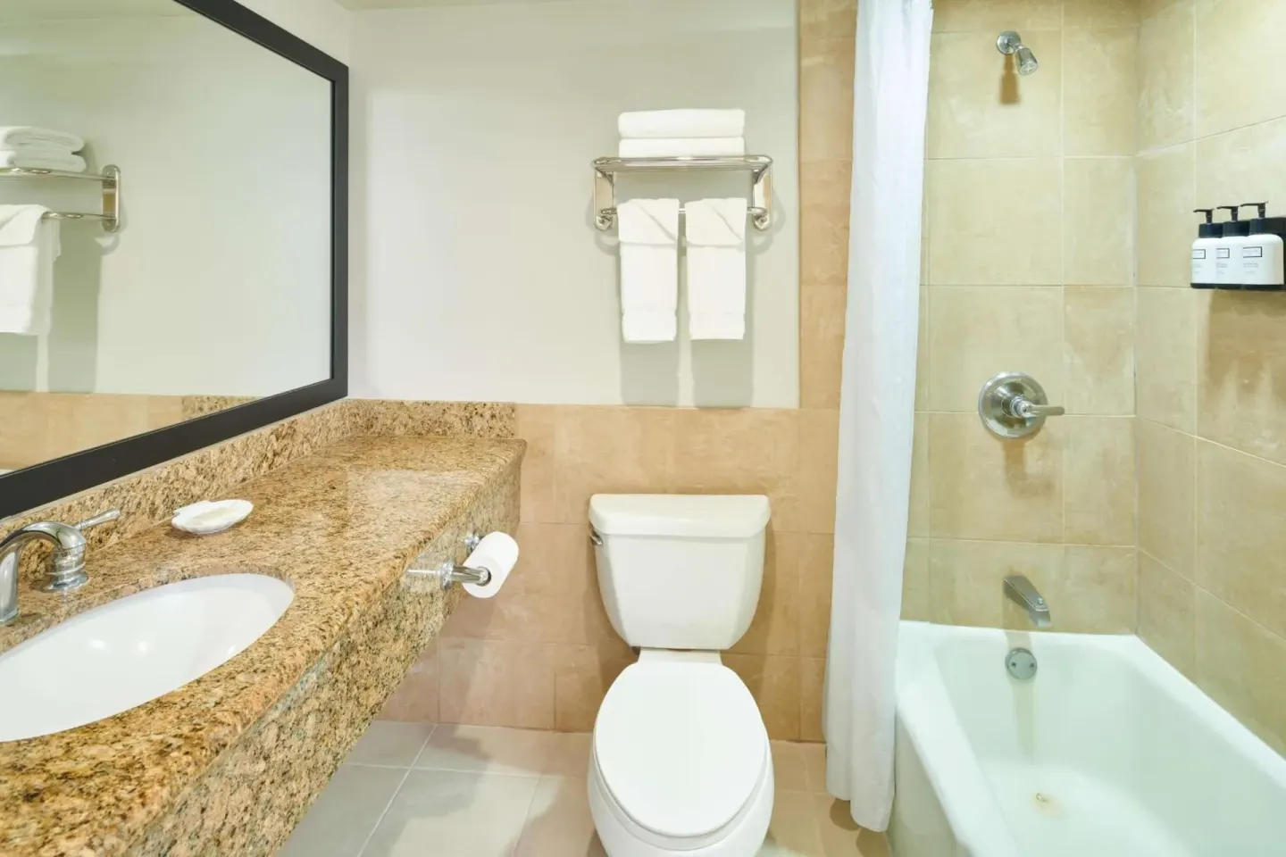 Bathroom with granite vanity and tub-shower at Aqua Palms Waikiki.