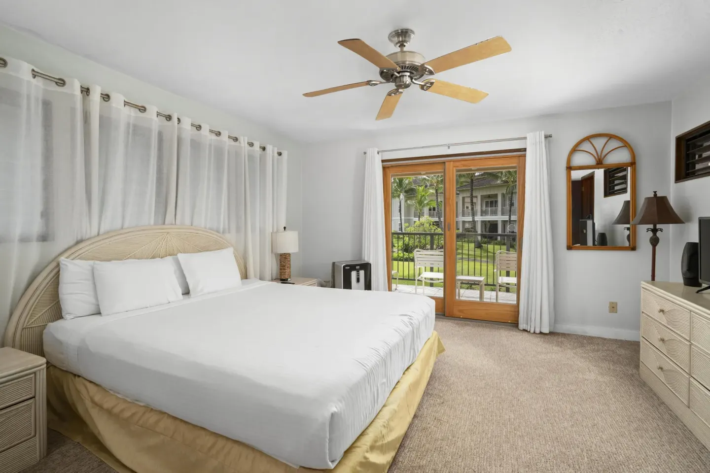 King bedroom with sliding glass doors to a patio at Aston at Poipu Kai.