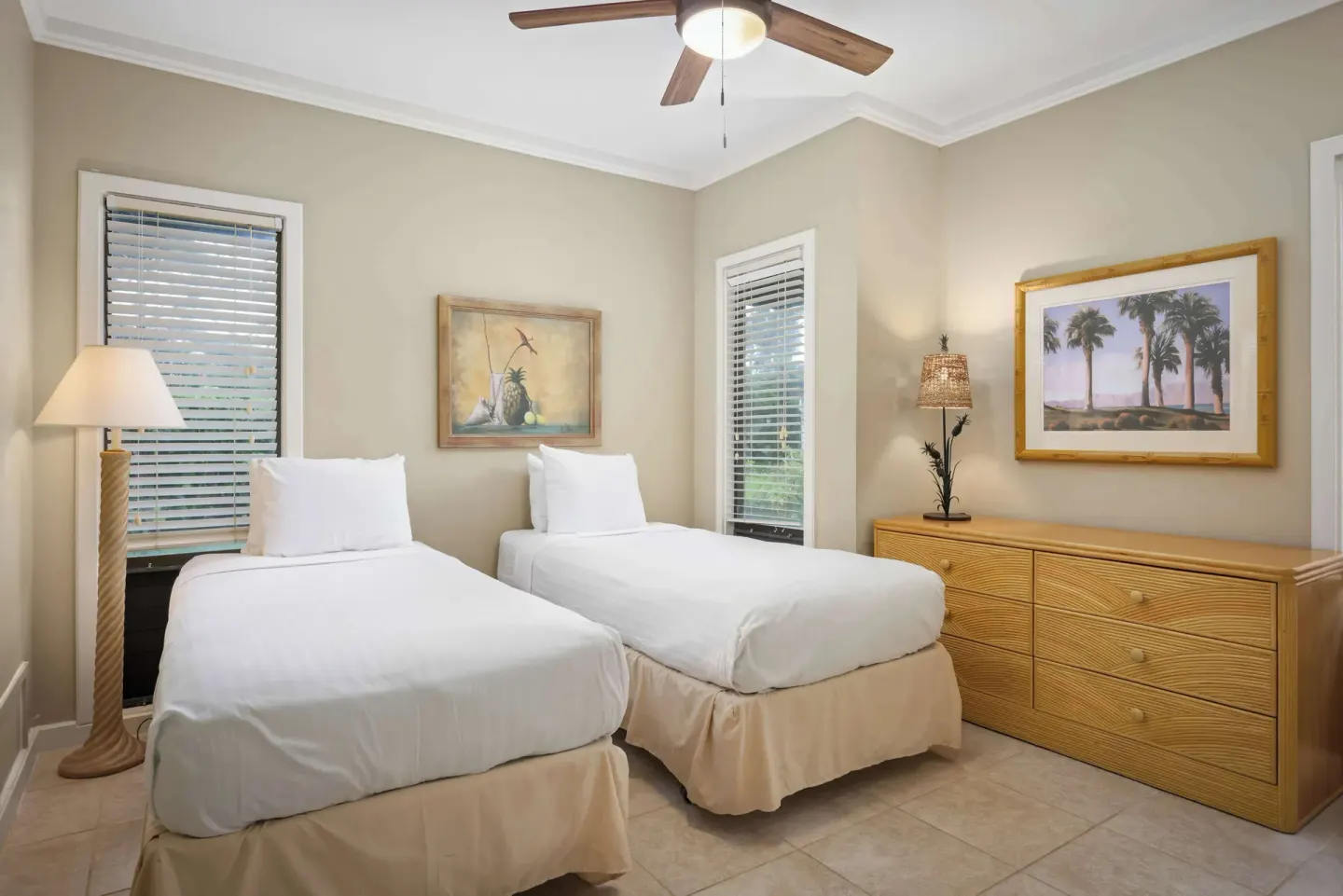 Guest bedroom with two twin beds, dresser and framed wall art at Aston at Poipu Kai.