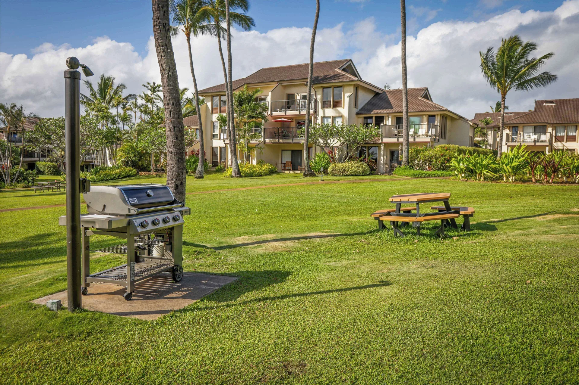 Barbecue grill and picnic table on the lawn at Aston at Poipu Kai.