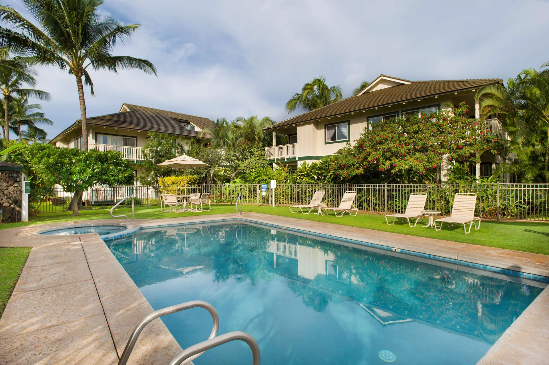 Pool and spa area with lounge chairs and tropical landscaping at Aston at Poipu Kai.