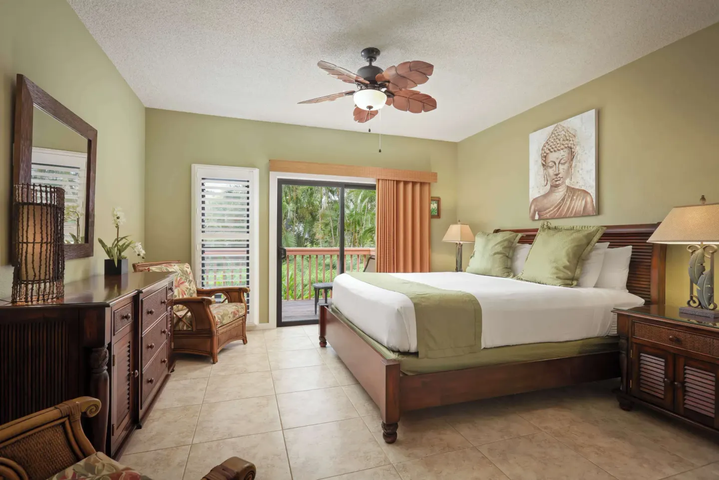 Tropical guest bedroom with king bed and balcony doors at Aston at Poipu Kai.