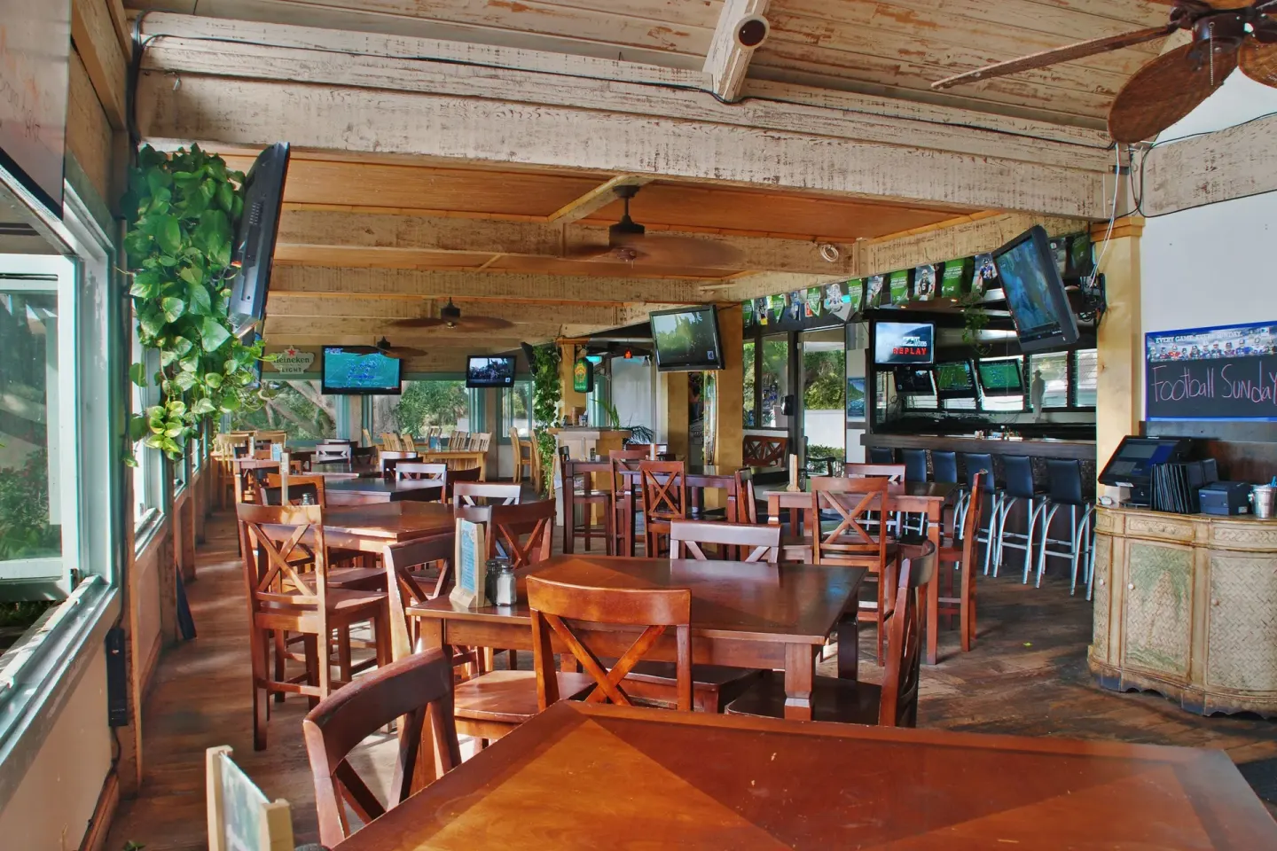 Sports bar dining room with TVs and wood tables at Aston at Poipu Kai.