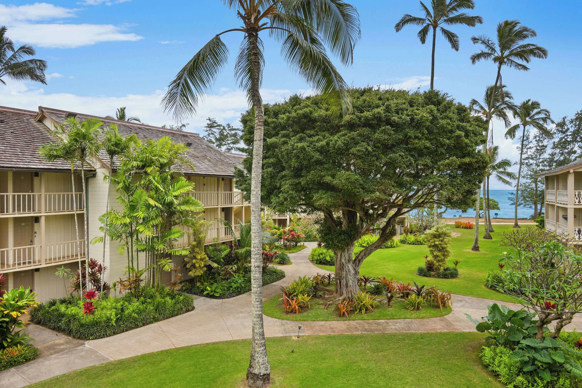 Courtyard gardens, palms, and ocean beyond at Aston Islander on the Beach.